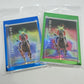 Two trading cards with colorful designs and text 'KA-YING RISING!' in a clear plastic sleeve on a white background.